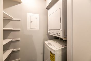 A white dryer is in a small laundry room at BellaVista Apartments in Woodbridge, VA